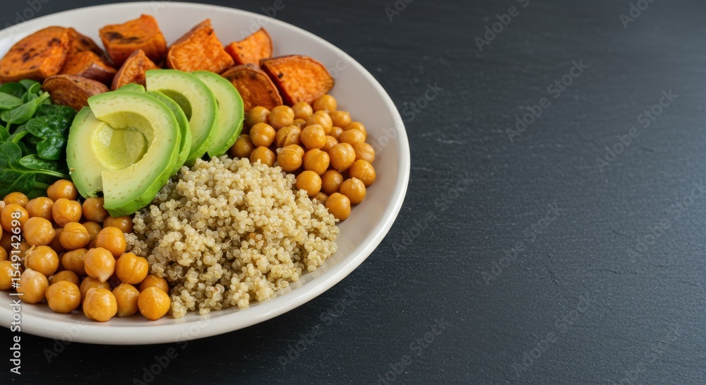 Healthy Vegetarian Bowl with Quinoa, Chickpeas, Sweet Potatoes and Fresh Avocado Slices on a Dark Stone Background Healthy Vegetarian Bowl with Quinoa, Chickpeas, Sweet Potatoes and Fresh Avocado Slices on a Dark Stone Background