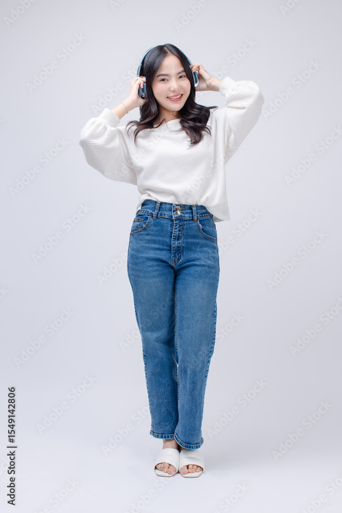 Portrait happy cheerful young asian beautiful woman curly hair wearing long sleeved shirt blue jeans outfit, casual headphones listen to music standing smile on white background joy positivity fashion Portrait happy cheerful young asian beautiful woman curly hair wearing long sleeved shirt blue jeans outfit, casual headphones listen to music standing smile on white background joy positivity fashion