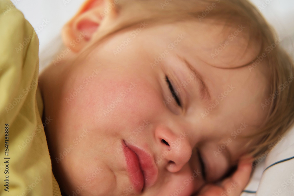 Peaceful adorable baby sleeping on a bed at home. Slumbering little child. Two years old girl sleeps peaceful at domestic room interior background. Serene dream. Cute face close up. Deep kid slumber Peaceful adorable baby sleeping on a bed at home. Slumbering little child. Two years old girl sleeps peaceful at domestic room interior background. Serene dream. Cute face close up. Deep kid slumber
