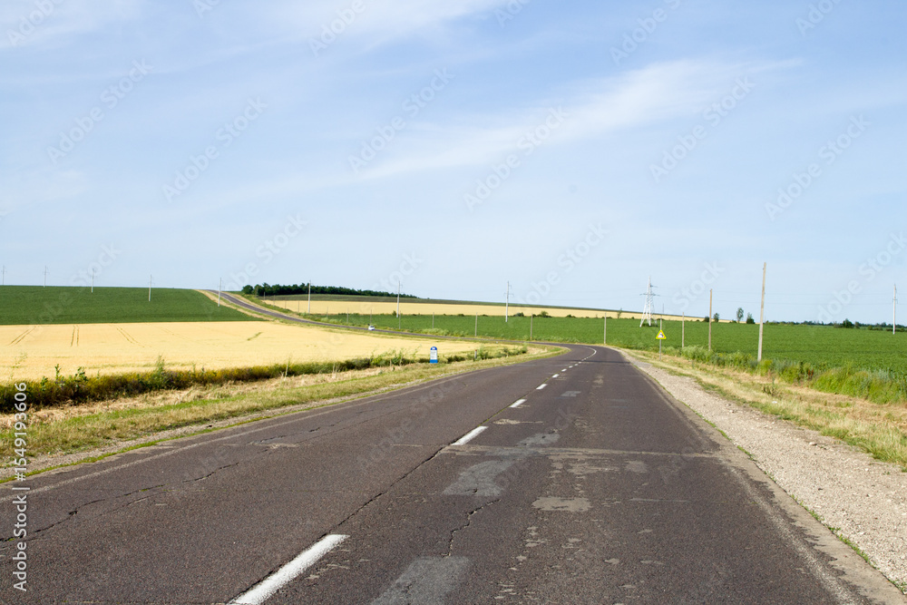 Fototapeta premium A road with grass and a blue sky