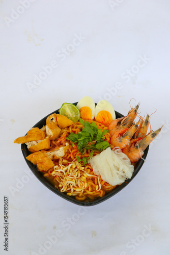 laksa, laksa curry made from vermicelli, noodles, bean sprouts, egg, tofu lime, and shrimp with a spicy soup sauce that is rich in spices. laksa served on bowl, isolated on white background.
