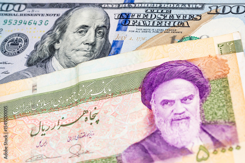 100 US dollar and 50000 Iranian rial banknotes. International trade concept