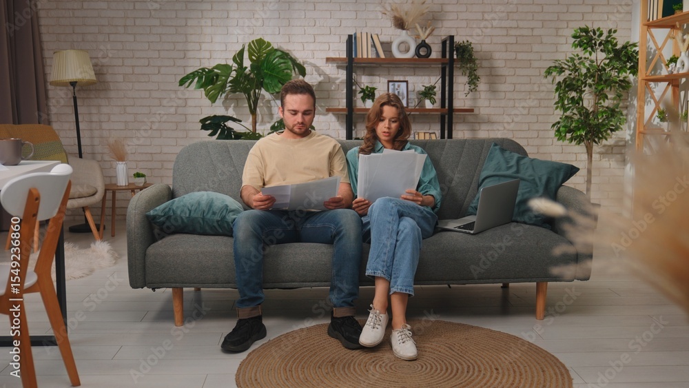Obraz premium Couple Shopping Online Using Laptop on Comfortable Sofa