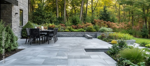 Fototapeta Naklejka Na Ścianę i Meble -  Modern patio with outdoor dining area overlooking lush landscaping