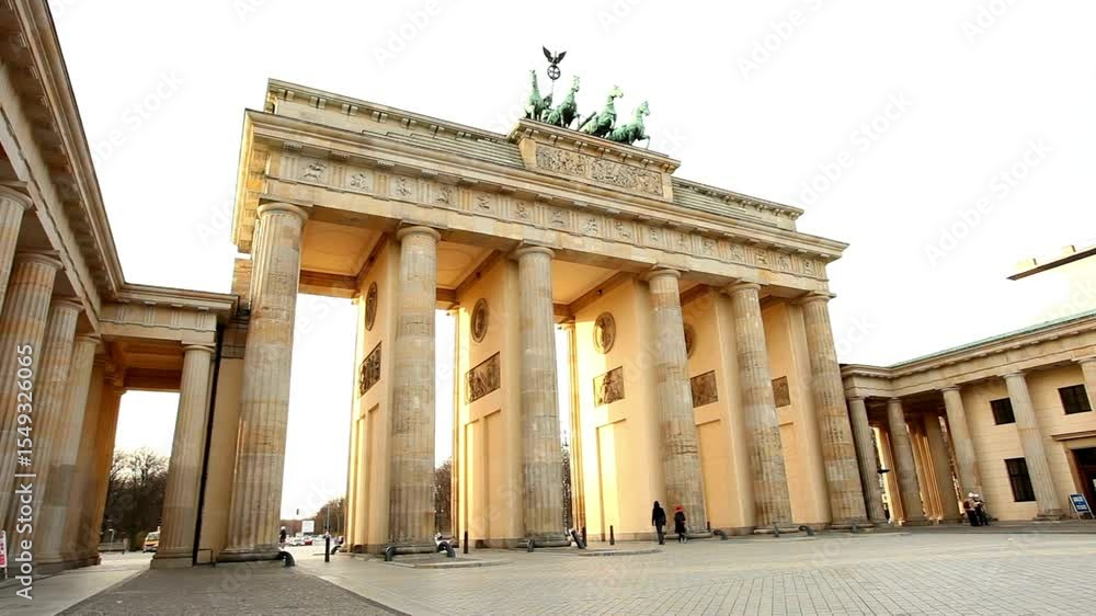 Visitors admire the iconic Brandenburg Gate during sunset in Berlin, witnessing the golden light illuminate the historic monument while people casually stroll around. Visitors admire the iconic Brandenburg Gate during sunset in Berlin, witnessing the golden light illuminate the historic monument while people casually stroll around.