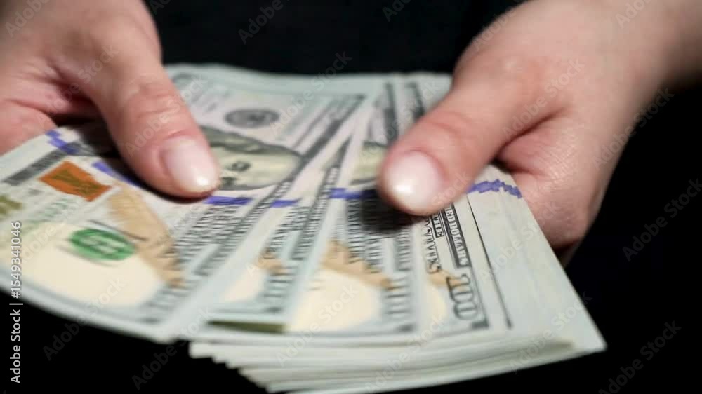 A bundle of dollar bills in female hands. Counting savings, salaries and income concept. Female hands counting a bundle of dollars banknotes. Closeup of woman Fingers counting a stack of dollar bills. A bundle of dollar bills in female hands. Counting savings, salaries and income concept. Female hands counting a bundle of dollars banknotes. Closeup of woman Fingers counting a stack of dollar bills.