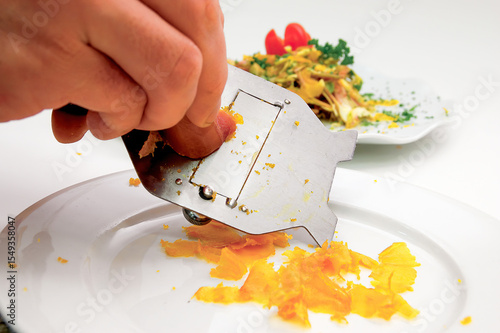 Chef grating bottarga over a white plate