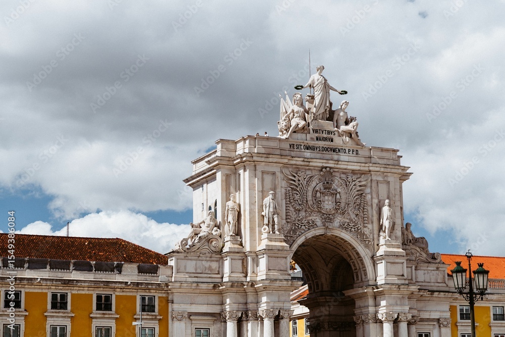 Obraz premium Rua Augusta Arch in Lisbon under a cloudy sky.