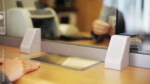 Employee and client count US dollar money on a counter at the currency exchange office. hands counting money in cash department window. business worker's hands counting dollar banknotes at the office.