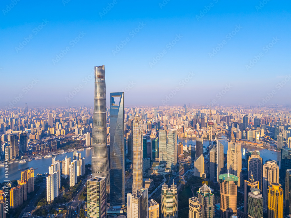 Fototapeta premium Aerial view of Shanghai skyscrapers in downtown with winding river on sunny day.