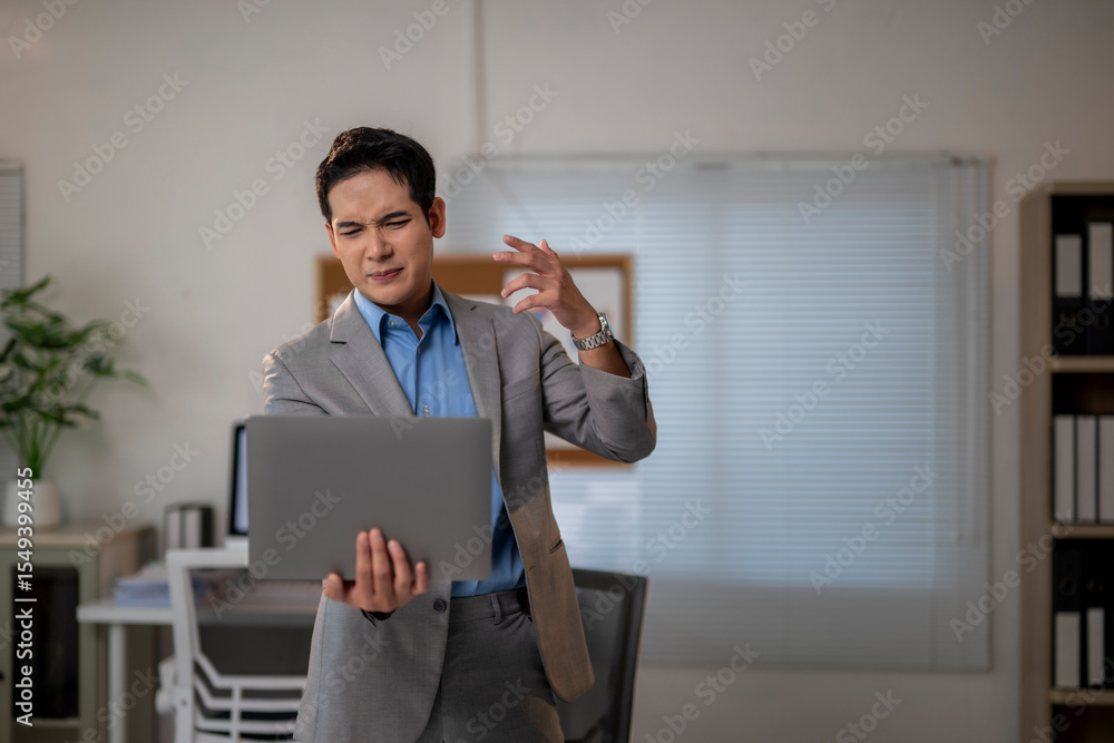 A man in a suit is looking at a laptop computer A man in a suit is looking at a laptop computer