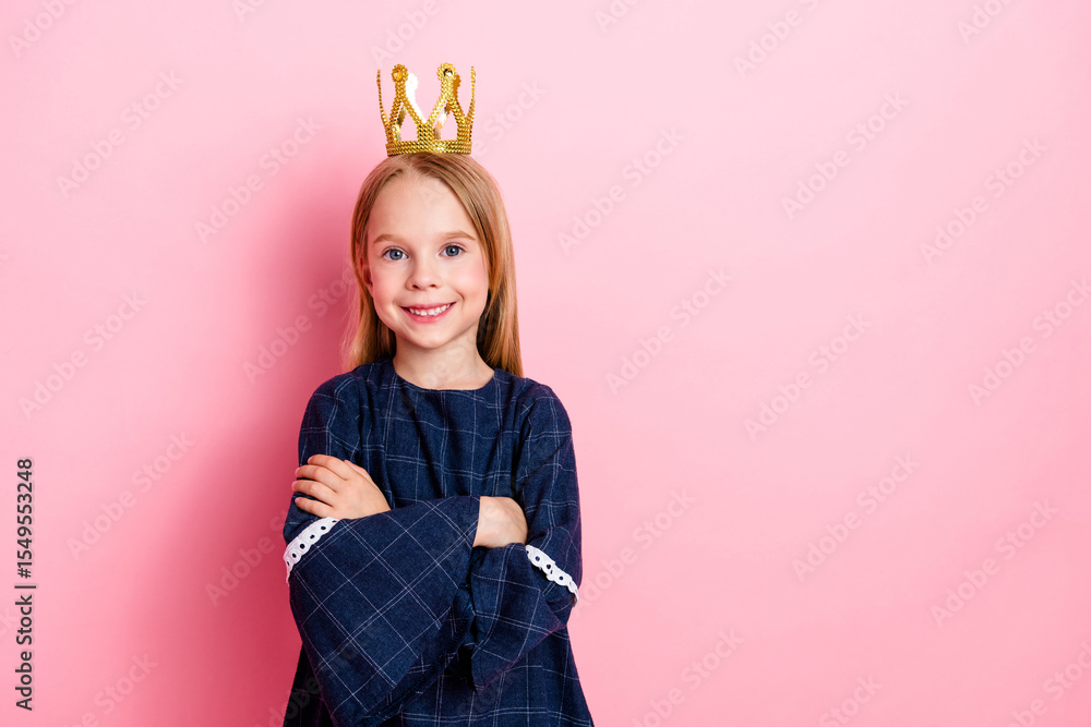 Smiling little girl wearing a crown on her head and standing proudly against a bright pink background Smiling little girl wearing a crown on her head and standing proudly against a bright pink background