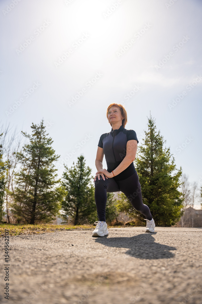 Woman stretching outdoors in a park during early morning exercise. Healthy routine, body mobility, and active lifestyle in nature. Woman stretching outdoors in a park during early morning exercise. Healthy routine, body mobility, and active lifestyle in nature.