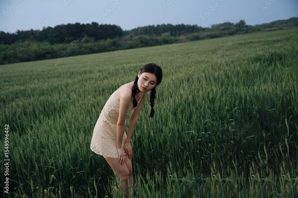 Young female in a field of green tall grass. Young female in a field of green tall grass.