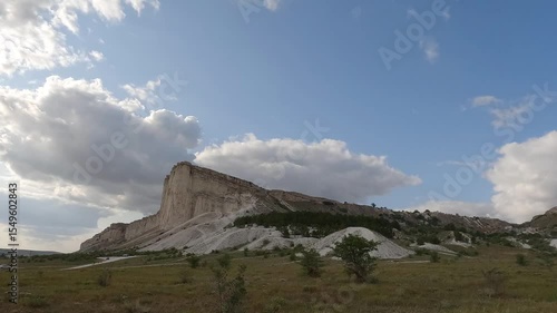 White sheer limestone cliff among running clouds, timelapse shooting