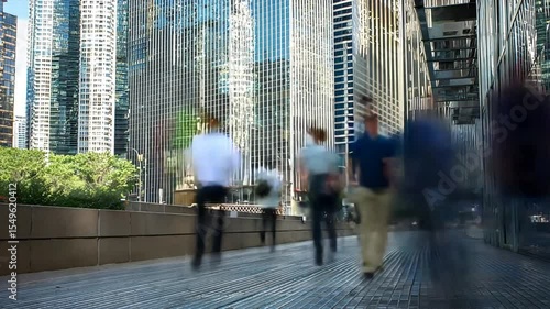 People walking on sidewalk near glass skyscrapers, background is blurred to show fast Traffic Flow with Speed Blur and time lapse movement in city
