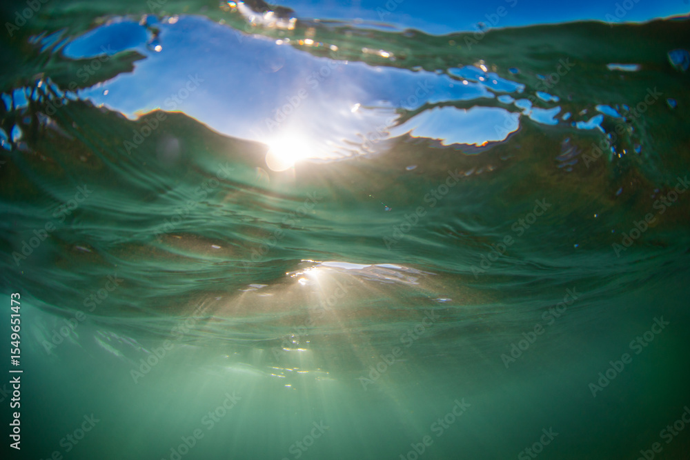 Obraz premium Warm sunlight shining through the ocean surface.