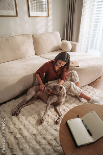 A woman is enjoying some time relaxing with her pet dog in a cozy living room setting