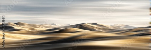 Wide desert dune meeting ocean waves with softly blurred sky backdrop under warm light
