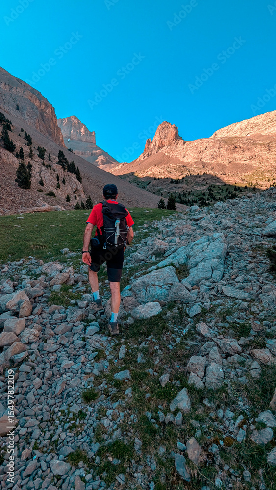 Obraz premium Trekker on the way to the Agujas de Lavasar, surrounded by impressive peaks and a rocky landscape of the Aragon Pyrenees, facing the majestic nature of the Chistau Valley. 