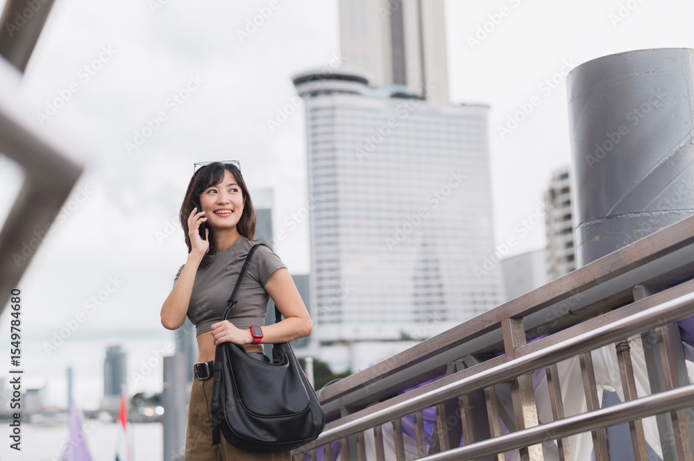 Solo southeast asian woman teenager blogger world travel tourism Bangkok Thailand express joy to friend smartphone. Wait for Chao Phraya river boat for local cultural experience. Asia explorer Solo southeast asian woman teenager blogger world travel tourism Bangkok Thailand express joy to friend smartphone. Wait for Chao Phraya river boat for local cultural experience. Asia explorer