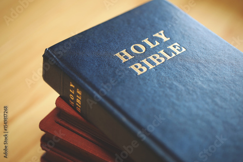 Fotografie Stack of Holy Bibles with a close-up focus on the top blue Bible