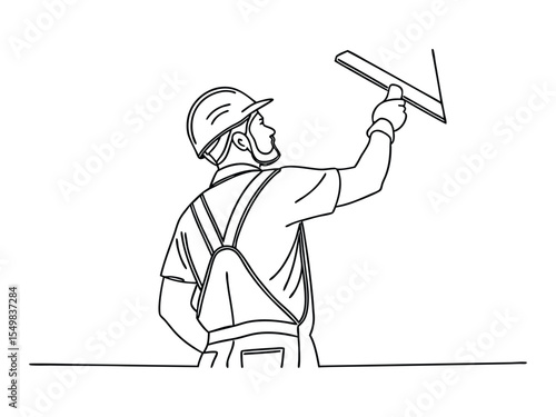A man working in uniform plastering the wall indoors