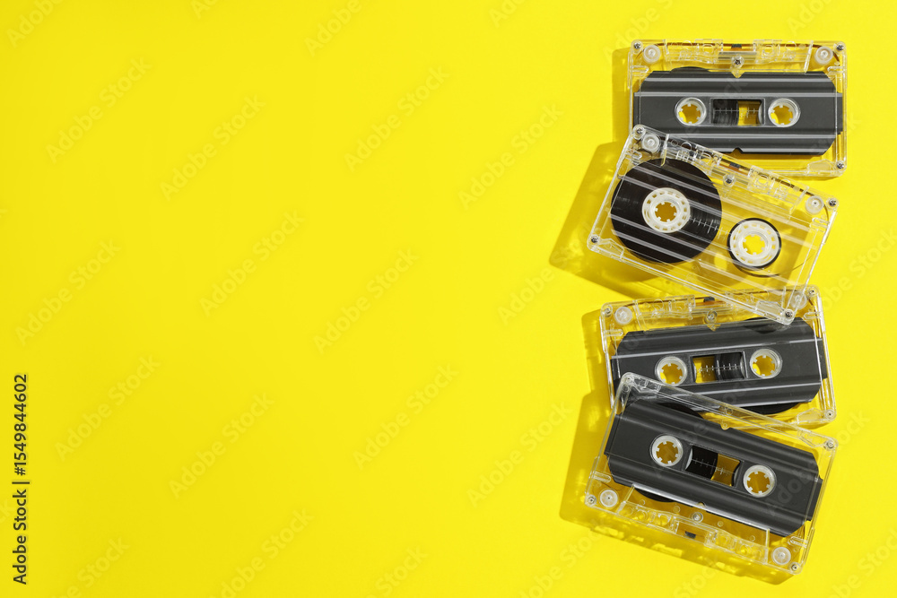 Audio cassettes with magnetic tapes on yellow background, flat lay. Space for text Audio cassettes with magnetic tapes on yellow background, flat lay. Space for text