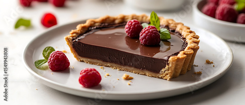 Fototapeta Naklejka Na Ścianę i Meble -  Decadent Chocolate Tart with Fresh Raspberries and Mint Garnish