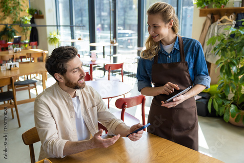 Waiter entering order on tablet at restaurant