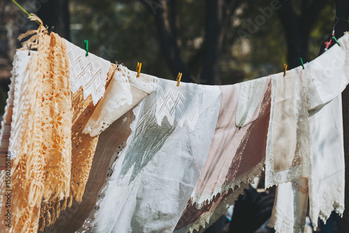 Vintage linens drying in the afternoon sunlight, delicate fabrics swaying gently on a clothesline, capturing the essence of a summer day at grandmother's house