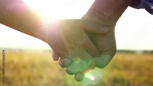 man woman holding hands suddenly let go begin argue. man walks away from woman, leaving her standing front alone. place during sunset. couple separation evident hands separate from each other.