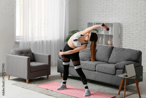 Young woman exercising with...