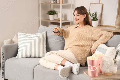 Young woman watching TV on ...