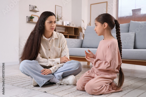Fotografie Cute girl apologizing to her mother at home