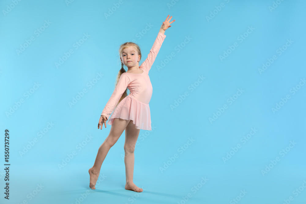 Obraz premium Cute little girl dancing on light blue background, space for text