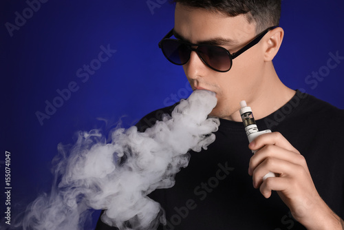 Young man in sunglasses smo...