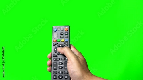 Hand holds TV remote and press the button, green screen background