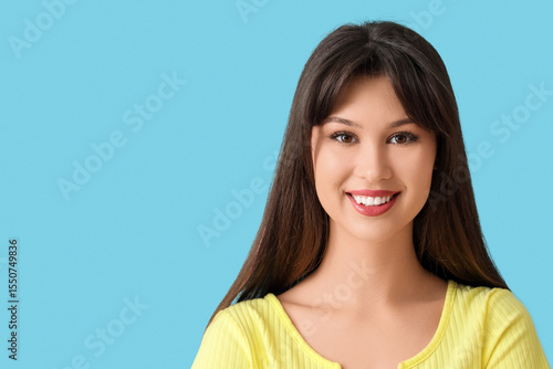 Smiling young woman on blue...