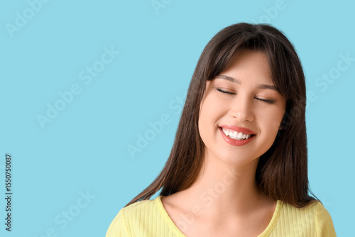 Smiling young woman on blue...
