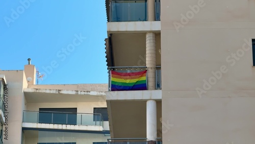 A Vibrant Pride Flag Decorates a Balcony, Amplifying Unity and Awareness in an Urban Area