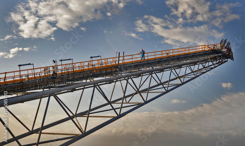 worker examines railing on an offshore platform flare boom