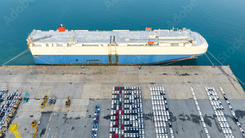 Aerial view Ro-Ro Ship of business logistic sea freight, New Cars produced by year up in the port for Cargo ship and Cargo import-export around in the world. cargo ship by tug boat