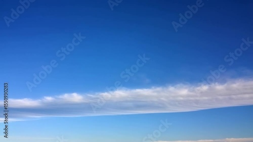 Clear blue sky with a band of wispy clouds