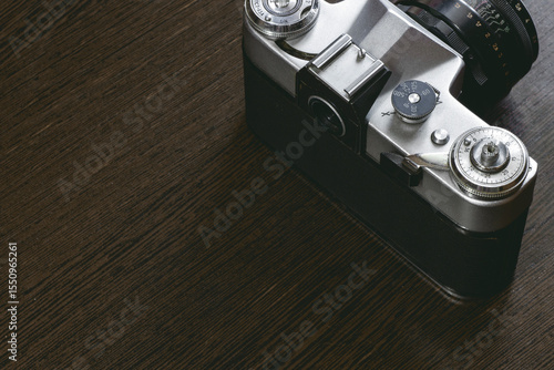 old mechanical camera. The controls such as the dials and shutter button are visible. The camera gives a vintage feel and looks like a classic retro camera.