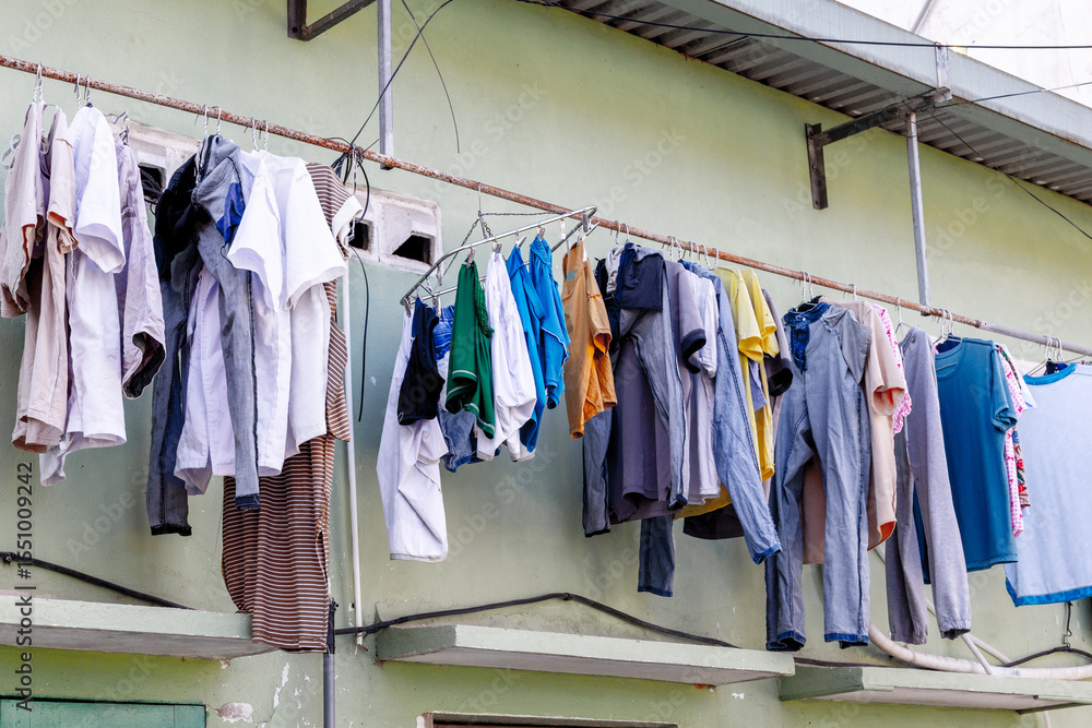 Obraz premium Assorted laundry hanging outdoors on clothesline against wall