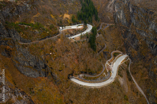 Fotografie Sharp hairpin turns of road intricately carved into rugged mountainside around Voringsfossen waterfall