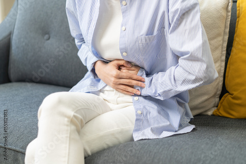 Slika na platnu Sick asian young woman in pain, hand holding belly, stomach pain from food poisoning, girl hurt abdomen ache and digestive problem, gastritis or diarrhea