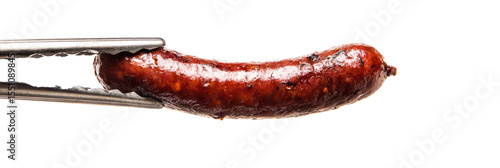 Sizzling sausage link held mid-air in tongs, glistening oil and browning, white background