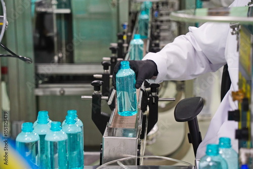 An employee checks liquid cosmetics at the factory.
